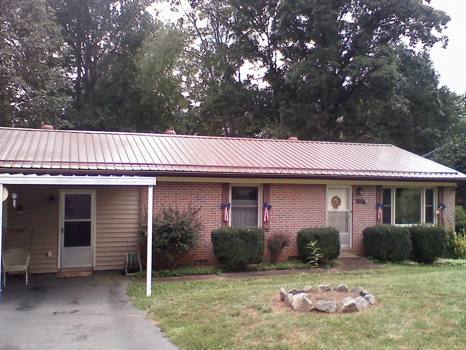 Bronze metal roof and carport on a brick ranch home — Roof Repair work by our crew in Fairplay